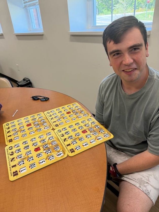 A man seated at a table with numbered bingo cards