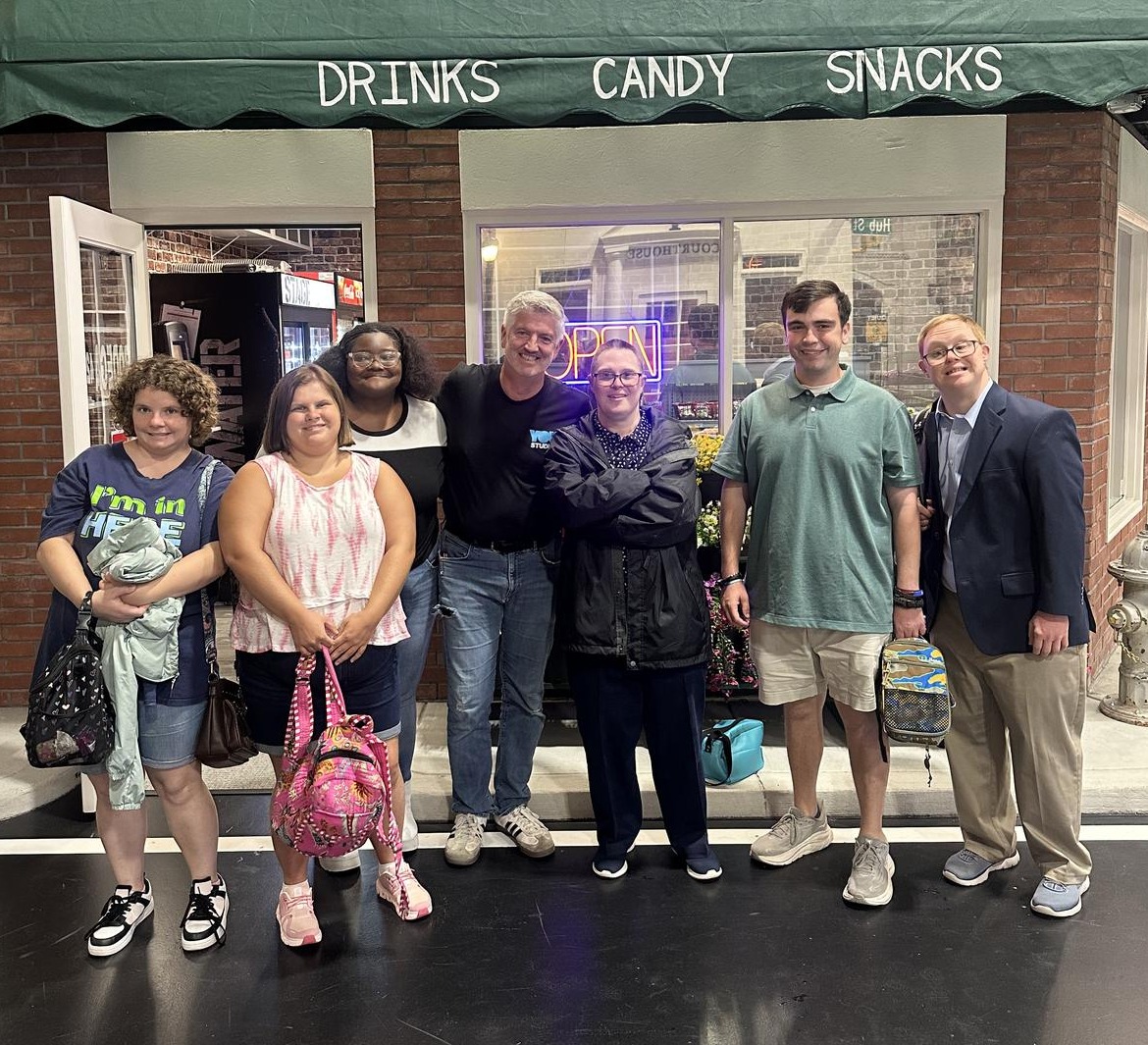 A group posing together in front of a Bodega 42 storefront