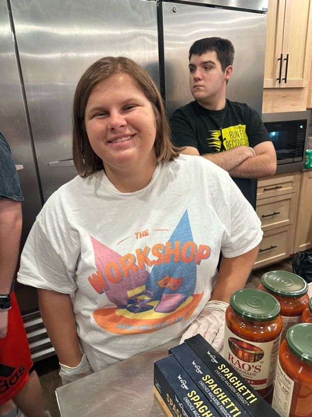 A smiling woman beside ingredients on a kitchen counter