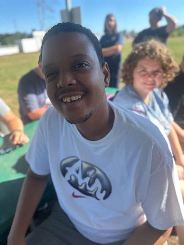A smiling young man enjoying time outdoors with a group