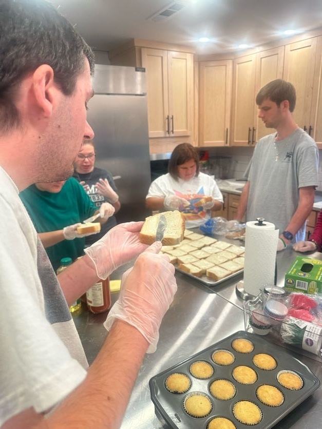 A group preparing bread and food together in a kitchen